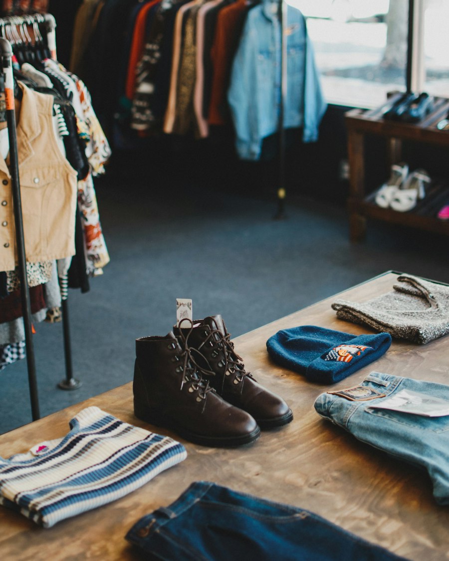 Leather boots with a price tag on a table in a resale shop, racks of clothing behind