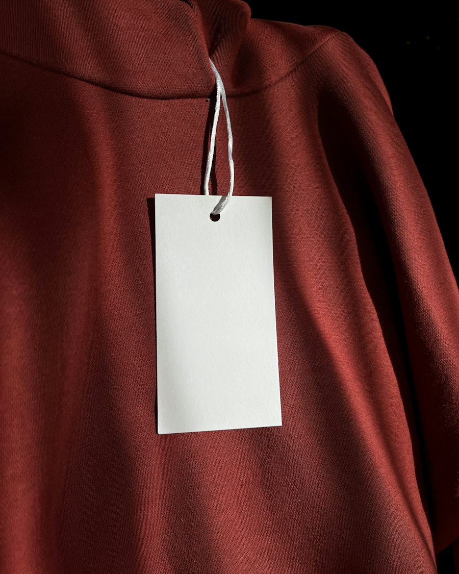 A blank white price tag hanging from a red sweater
